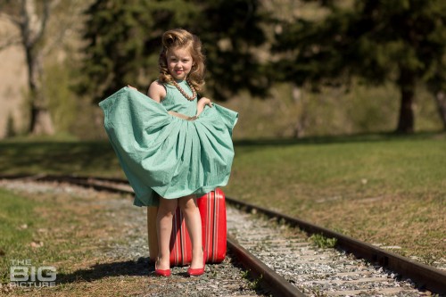 children's photography, young girl in high heels and vintage hair curtsy by railroad tracks, runaway, vintage victory rolls, pin up photography